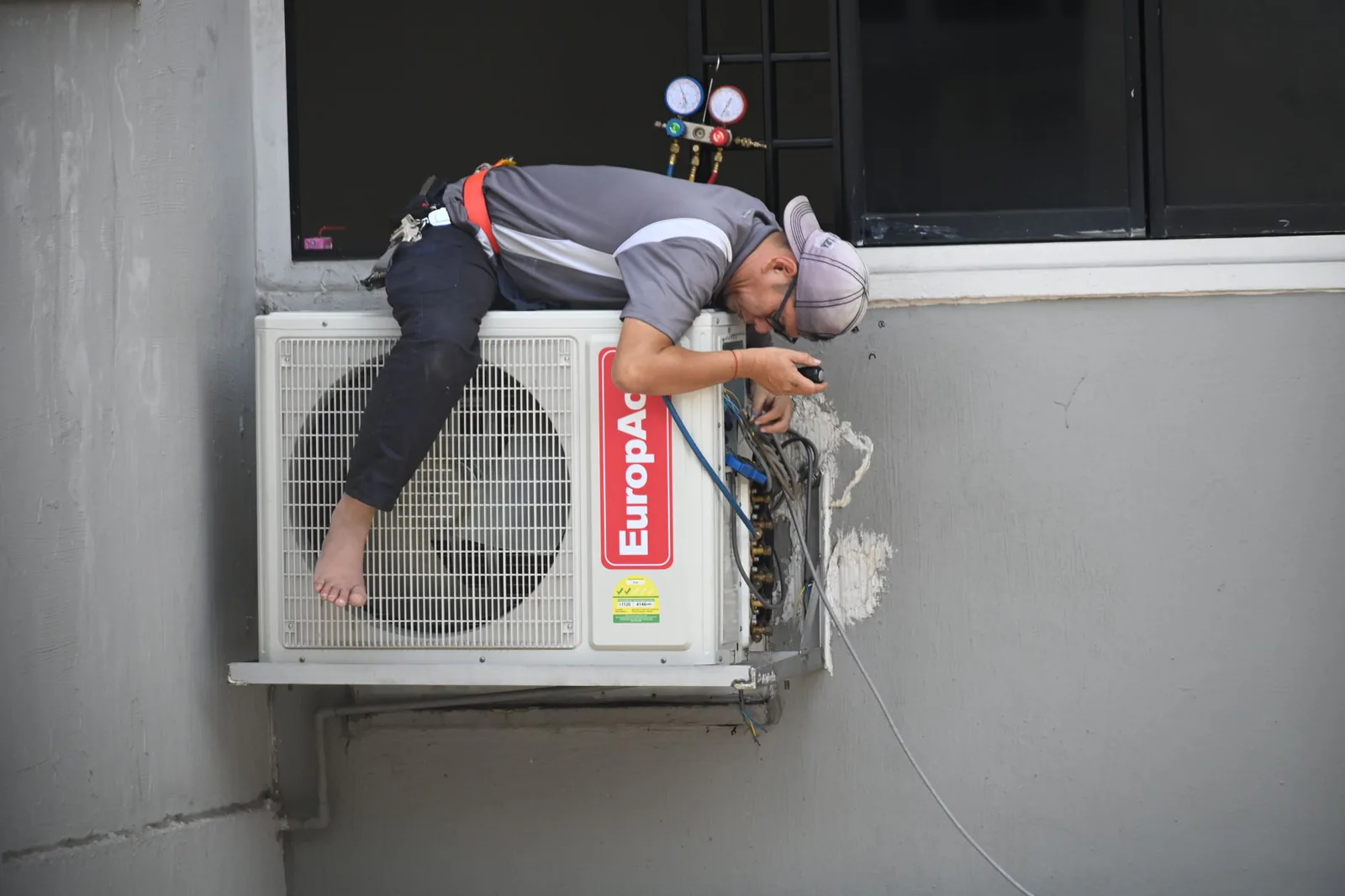 Technician installing a high-efficiency air conditioning unit