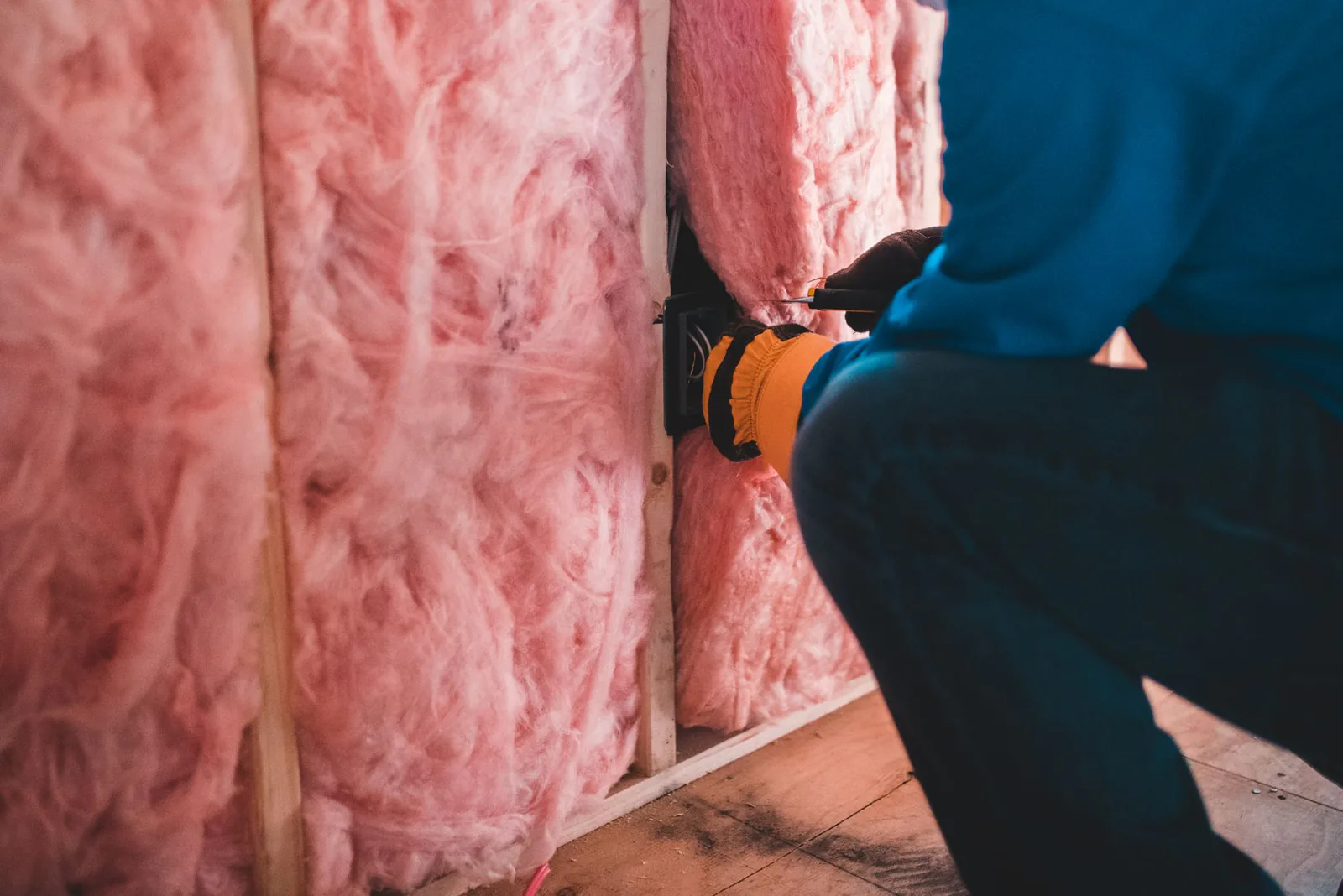 Worker installing insulation in a building